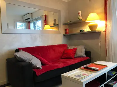 a red couch in a living room with a table at Cannes Les Pins in Cannes