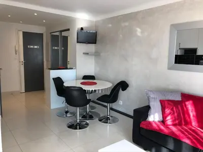a living room with a table and chairs and a couch at Cannes Les Pins in Cannes