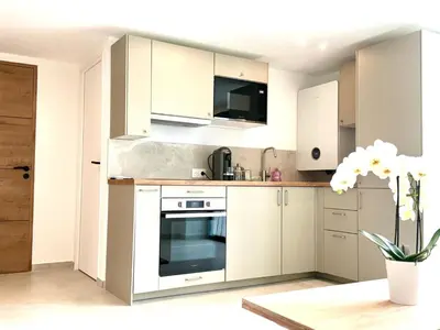 a kitchen with white cabinets and an oven at Appartment Jacuzzi in Cannes in Cannes
