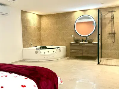 a bathroom with a tub and a sink and a mirror at Appartment Jacuzzi in Cannes in Cannes