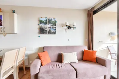 a living room with a gray couch with orange pillows at Résidence Cannes Villa Francia - maeva Home - Appartement 2 pièces 6 personnes avec vue mer - Sélection - super Home MAE-3641 in Cannes