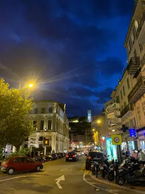 a busy city street at night with cars parked at RenTcik in Cannes