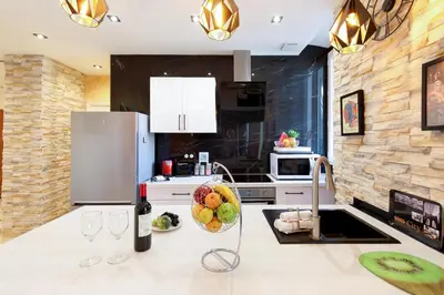 a kitchen with a counter with wine glasses and a refrigerator at Little Garden YourHostHelper in Cannes