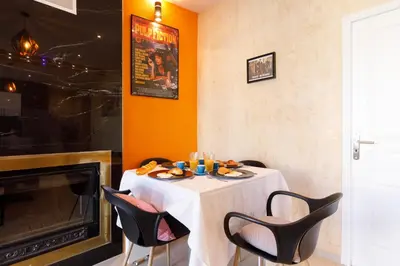 a dining room with a table with chairs and a fireplace at Little Garden YourHostHelper in Cannes