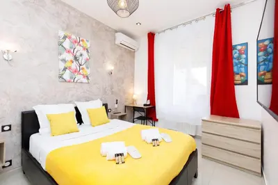 a bedroom with a large bed and red curtains at Little Garden YourHostHelper in Cannes