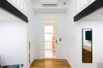 a room with white walls and a door and a mirror at Little Garden YourHostHelper in Cannes
