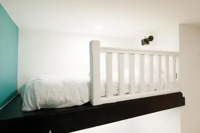a white crib in a white room with a window at Little Garden YourHostHelper in Cannes