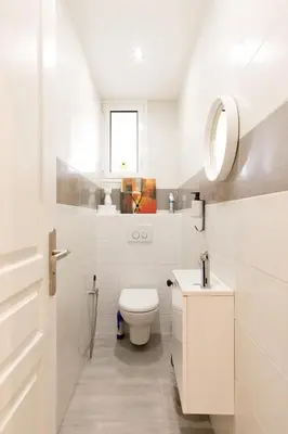 a white bathroom with a toilet and a sink at Little Garden YourHostHelper in Cannes