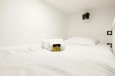 a white bed with white sheets and pillows at Little Garden YourHostHelper in Cannes