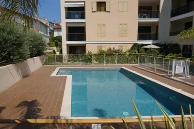 a swimming pool in front of a building at Apartment Palm Beach with a nice swimming pool in Cannes