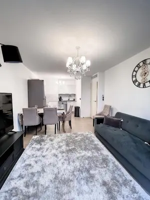 a living room with a couch and a clock on the wall at Apartment Palm Beach with a nice swimming pool in Cannes