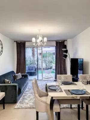 a living room with a table and a couch at Apartment Palm Beach with a nice swimming pool in Cannes