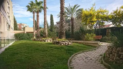 a garden with palm trees and a brick walkway at Nicolas 2 in Cannes