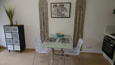 a table and chairs in a room with a kitchen at Nicolas 2 in Cannes