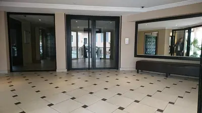 a lobby with glass doors and a black bench at Nicolas 2 in Cannes