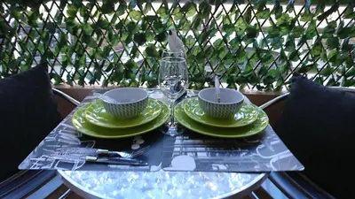 a table with green plates and a glass of wine at Nicolas 2 in Cannes