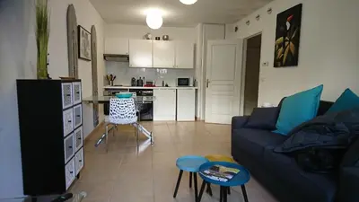 a living room with a blue couch and a kitchen at Nicolas 2 in Cannes