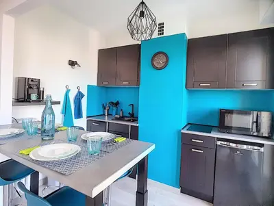 a kitchen with a table and a blue wall at ROOFTOP#PLAGES#APERCU MER#CLIM#Festival in Cannes