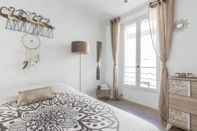 a white bedroom with a bed and a window at LB Vacation Rentals I Cute Affordable 1-Br Minutes From Cannes Center in Cannes