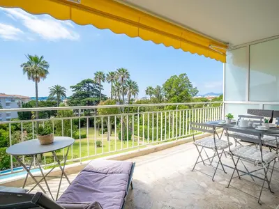 a patio with a table and chairs and a balcony at Apartment Les Pervenches by Interhome in Cannes