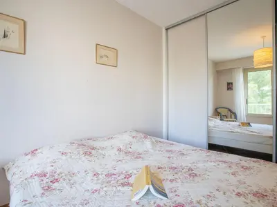 a bedroom with a bed with a book on it at Apartment Les Pervenches by Interhome in Cannes