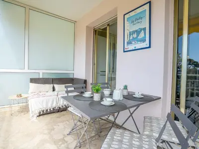 a table and chairs in a living room with a couch at Apartment Les Pervenches by Interhome in Cannes
