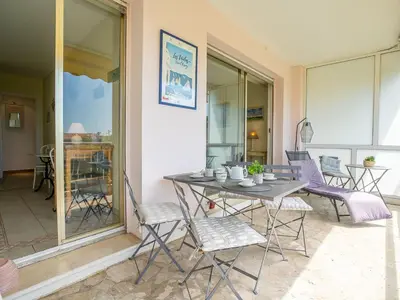 a patio with a table and chairs on a balcony at Apartment Les Pervenches by Interhome in Cannes