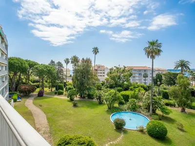 a balcony view of a park with a swimming pool at Apartment Les Pervenches by Interhome in Cannes
