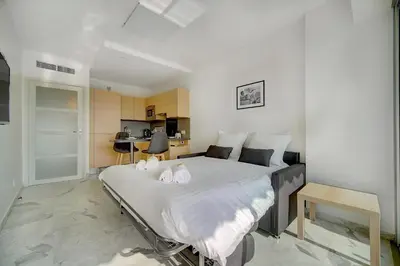 a bedroom with a large bed with white sheets at IMMOGROOM- Magnificent View - NEW - Terrace - AC in Cannes