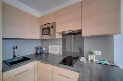 a kitchen with a sink and a microwave at IMMOGROOM- Magnificent View - NEW - Terrace - AC in Cannes