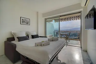 a bedroom with a large bed with a large window at IMMOGROOM- Magnificent View - NEW - Terrace - AC in Cannes