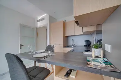 a kitchen with a counter with two chairs and a table at IMMOGROOM- Magnificent View - NEW - Terrace - AC in Cannes