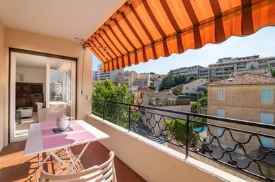 a balcony with a table and a view of a city at COPACABANA appartement 2 chambres in Cannes