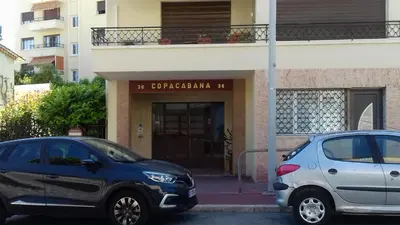 two cars parked in front of a building at COPACABANA appartement 2 chambres in Cannes