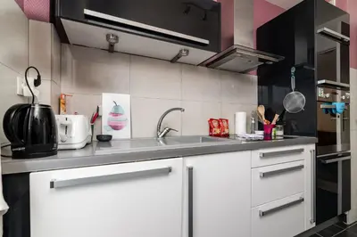a kitchen with white cabinets and a sink at COPACABANA appartement 2 chambres in Cannes