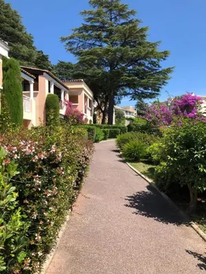 a walkway through a garden with flowers and trees at Sea views and beautiful pool in Cannes
