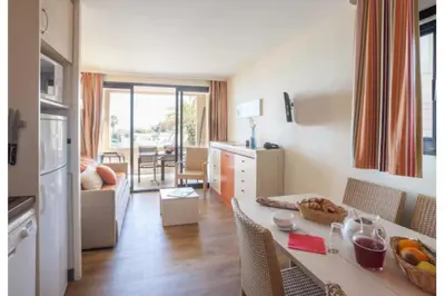 a kitchen and living room with a table and chairs at Sea views and beautiful pool in Cannes