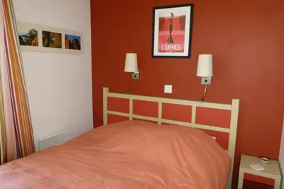 a bedroom with a bed and two lights on the wall at Sea views and beautiful pool in Cannes