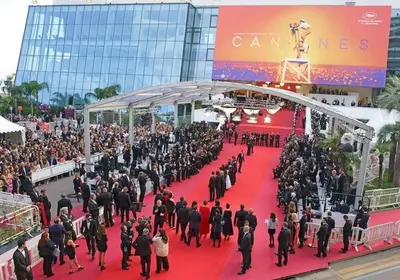a large crowd of people walking on a red carpet at T2 proximité MIPIM in Cannes