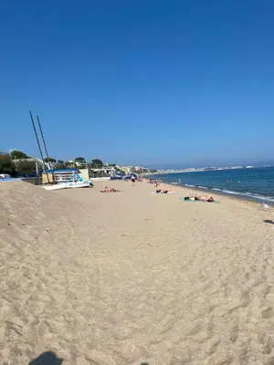 a beach with people laying on the sand at Chambre spacieuse indépendante dans villa plus parking privée in Le Cannet