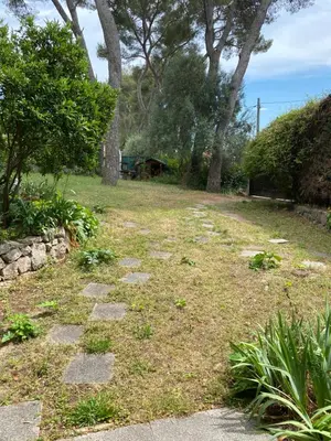 a stone path in a yard with trees and grass at Chambre spacieuse indépendante dans villa plus parking privée in Le Cannet