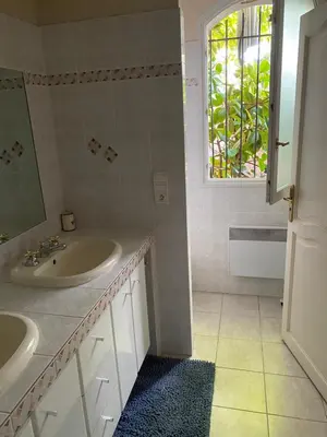 a bathroom with a sink and a mirror and a window at Chambre spacieuse indépendante dans villa plus parking privée in Le Cannet