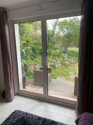 a sliding glass door with a view of a garden at Chambre spacieuse indépendante dans villa plus parking privée in Le Cannet