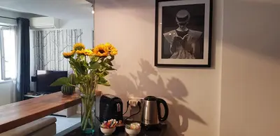 a vase of flowers on a table with a picture at Superbe 2 pièces au calme absolu in Cannes