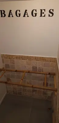 a shelf on a brick wall with the word baggage on it at Superbe 2 pièces au calme absolu in Cannes