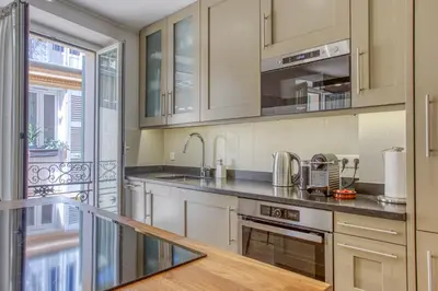 a kitchen with white cabinets and stainless steel appliances at Style in Cannes-Beautiful Apt-5 mins stroll to Festival-Beach-Port in Cannes