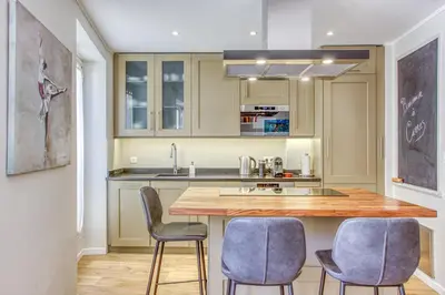 a kitchen with a wooden counter and blue chairs at Style in Cannes-Beautiful Apt-5 mins stroll to Festival-Beach-Port in Cannes