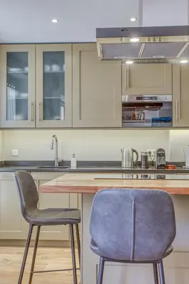 a kitchen with two chairs and a wooden counter at Style in Cannes-Beautiful Apt-5 mins stroll to Festival-Beach-Port in Cannes
