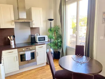 a kitchen with a table and a dining room at Latour Maubourg By SCLS Locations in Cannes