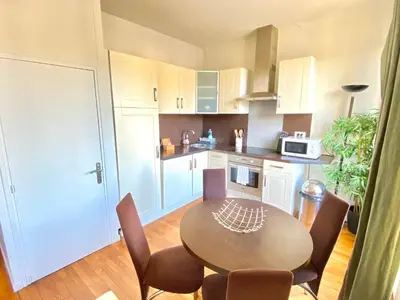 a kitchen with a table and chairs in a room at Latour Maubourg By SCLS Locations in Cannes